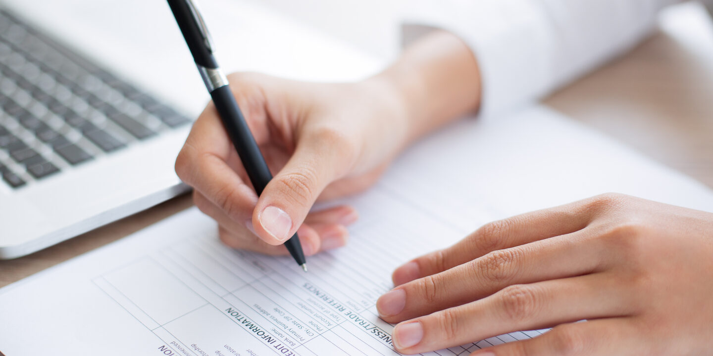 Closeup of Business Person Completing Form